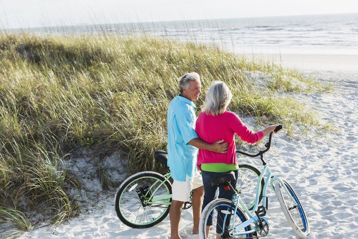 Ouder stel met fietsen bij de duinen aan het strand